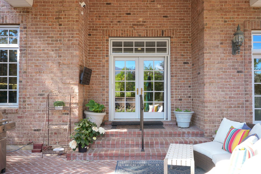 View of exterior entry featuring french doors and brick siding