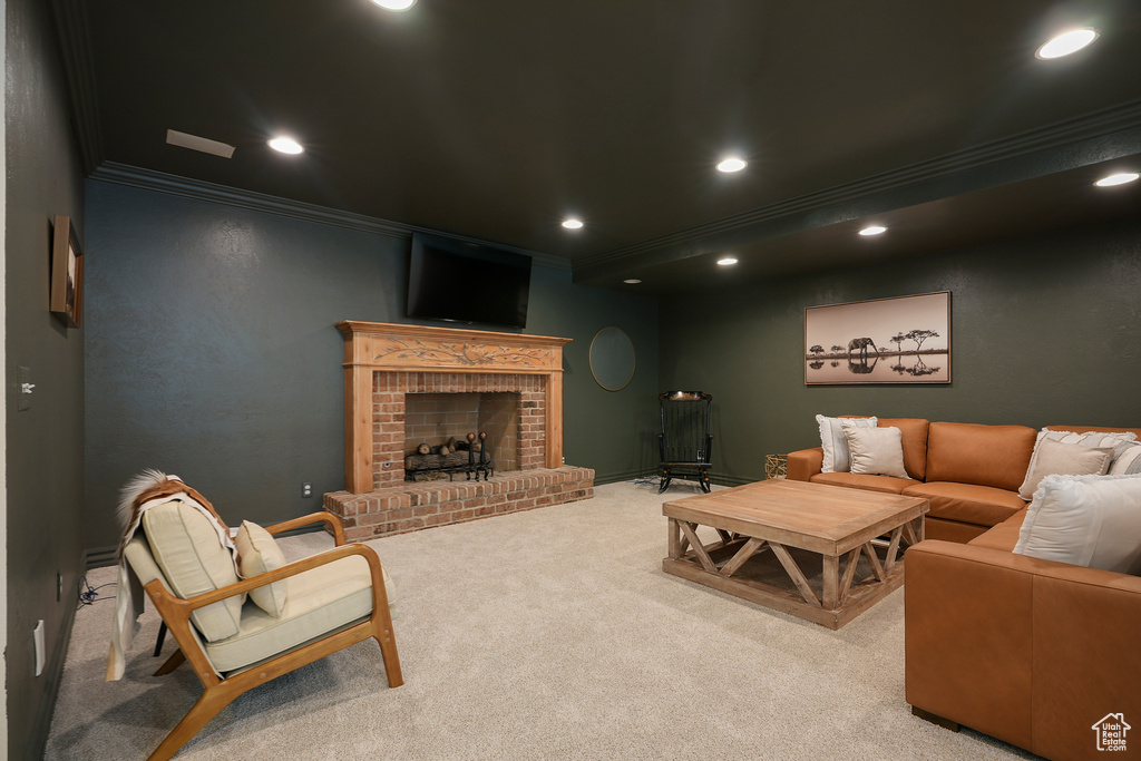 Carpeted living room featuring crown molding, recessed lighting, a brick fireplace, and baseboards