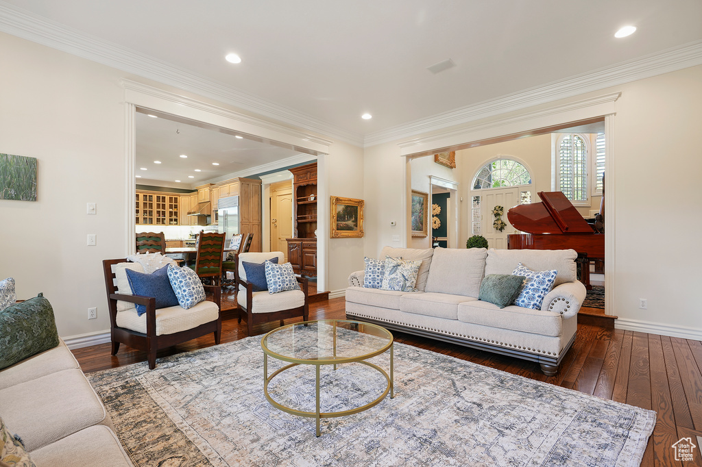 Living room with baseboards, dark wood-style flooring, recessed lighting, and ornamental molding