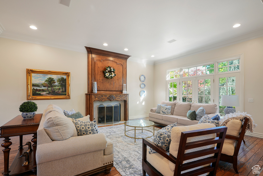 Living room with recessed lighting, baseboards, hardwood / wood-style flooring, crown molding, and a fireplace