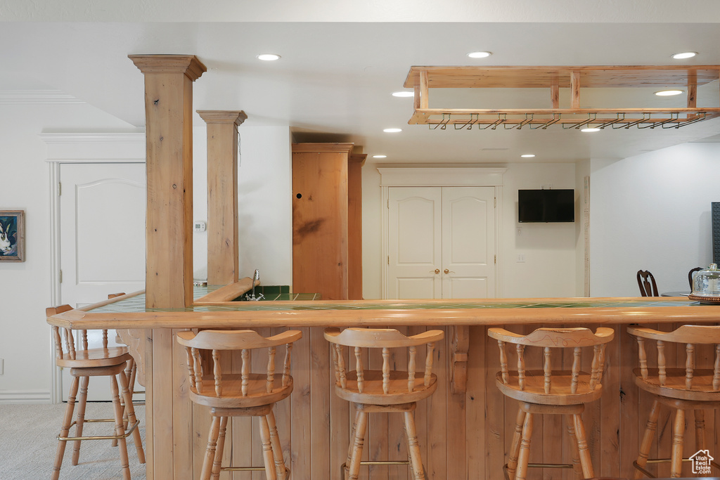 Indoor wet bar with recessed lighting and carpet floors