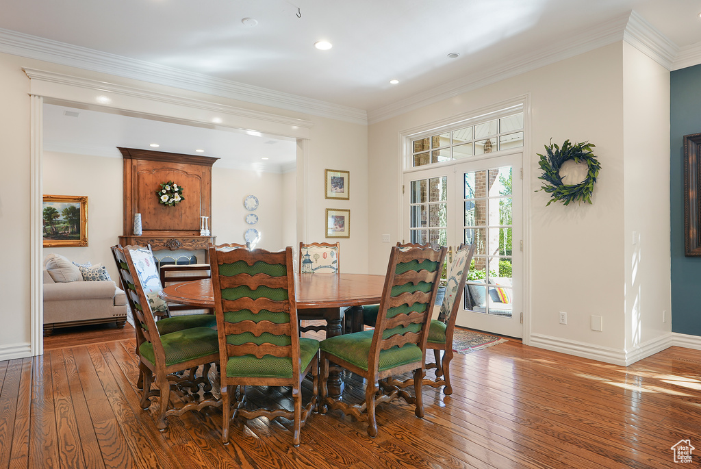 Dining area featuring wood-type flooring, baseboards, ornamental molding, and recessed lighting