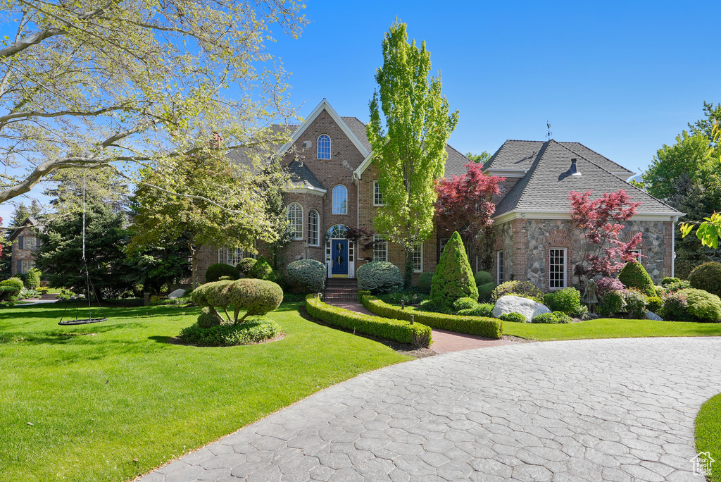 View of front of house with a front yard and brick siding