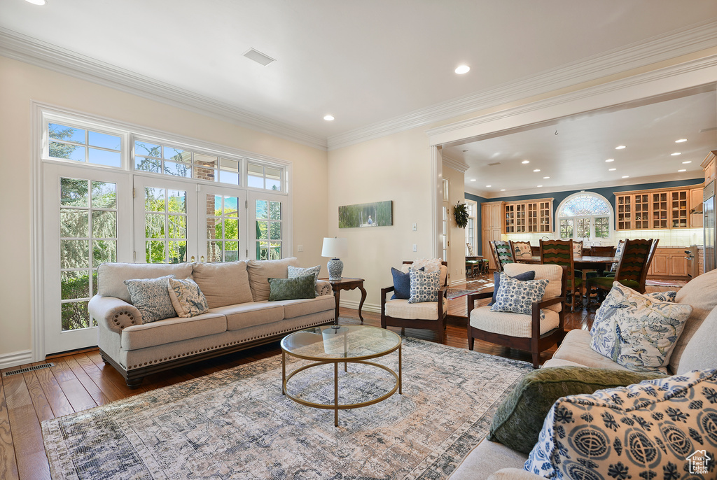 Living area featuring wood-type flooring, recessed lighting, baseboards, and crown molding