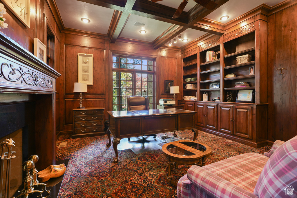 Office with ornamental molding, wooden walls, beam ceiling, coffered ceiling, and built in features