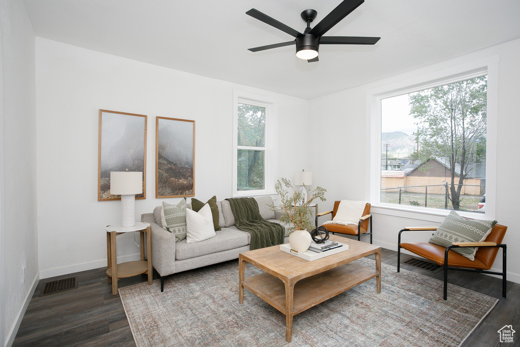 Living room with wood finished floors, a ceiling fan, and baseboards
