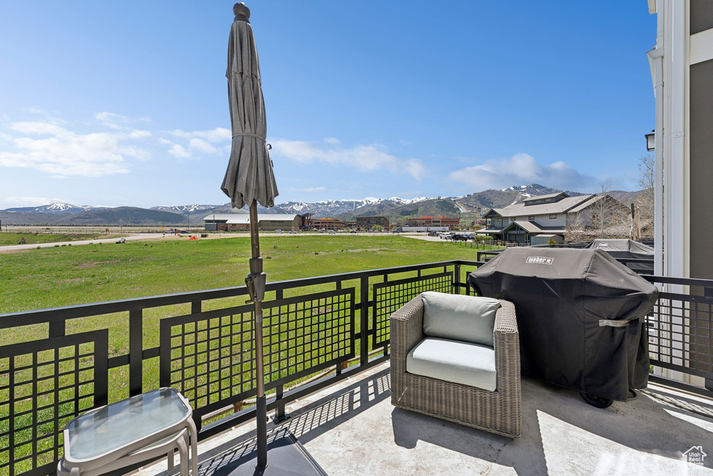 View of patio featuring a mountain view, a balcony, and a view of countryside