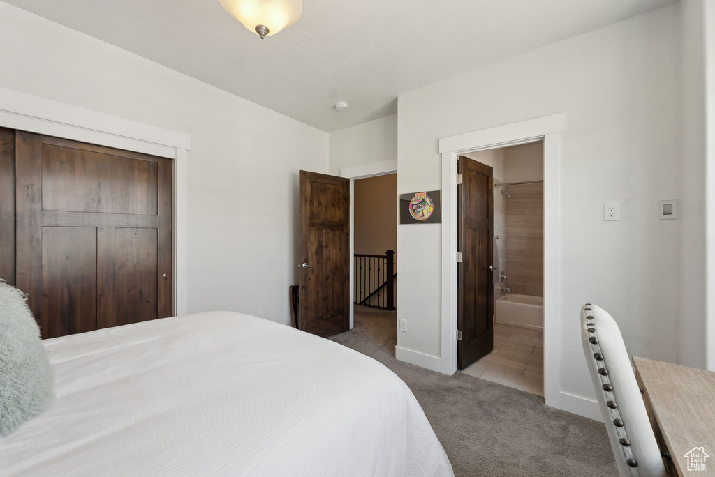Carpeted bedroom with baseboards, a closet, and ensuite bathroom