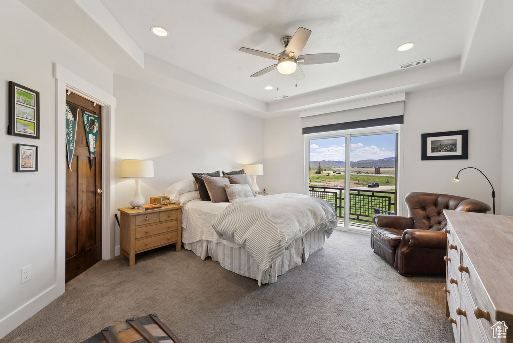 Bedroom with a tray ceiling, carpet flooring, access to outside, recessed lighting, and a ceiling fan