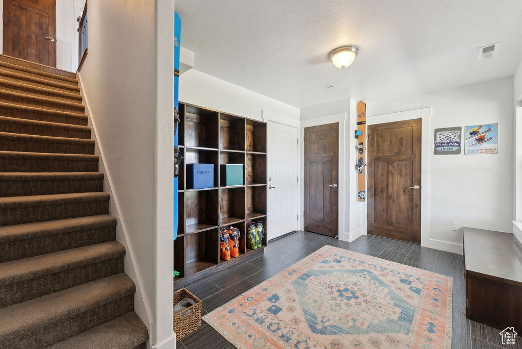 Foyer entrance featuring stairs, baseboards, and wood finish floors
