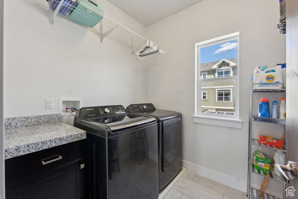 Laundry room featuring washer and dryer and baseboards