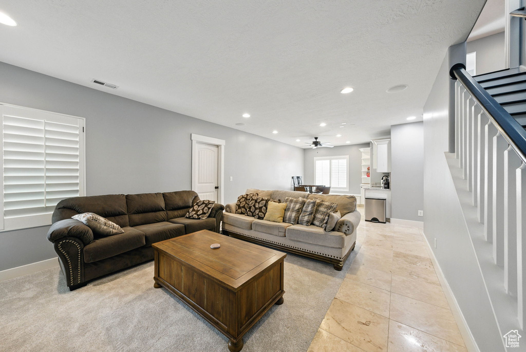 Living room featuring stairs, recessed lighting, baseboards, and a ceiling fan