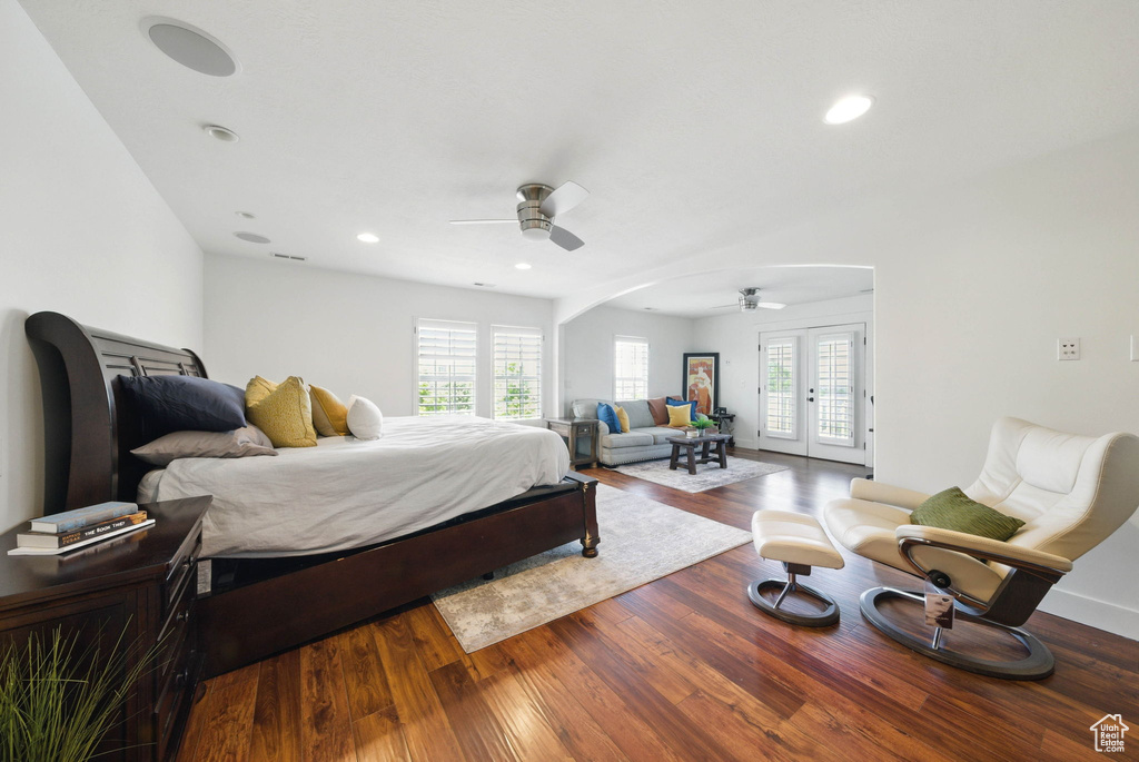 Bedroom featuring multiple windows, access to exterior, arched walkways, wood finished floors, and recessed lighting