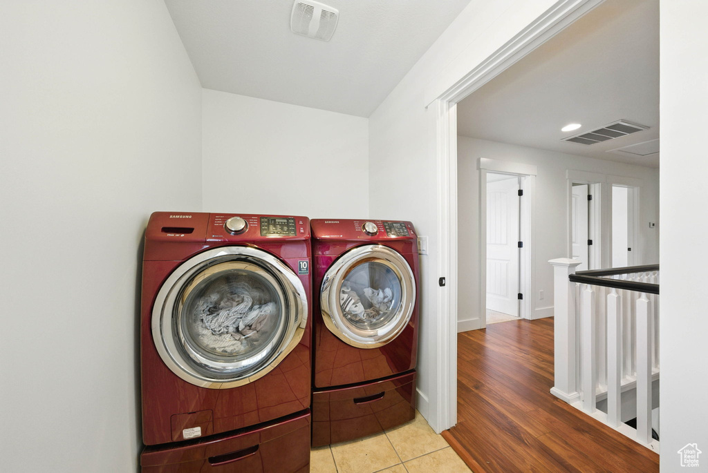 Laundry area featuring independent washer and dryer, tile patterned flooring, baseboards, and recessed lighting