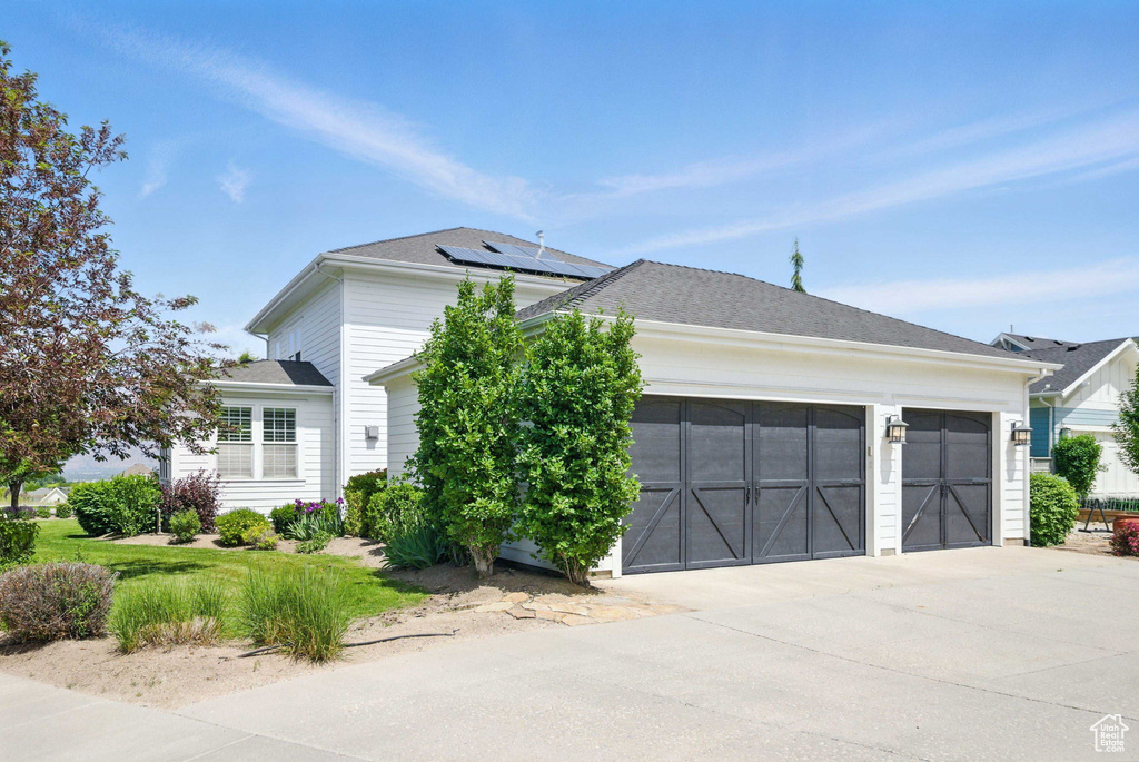 View of front of house with an attached garage and driveway