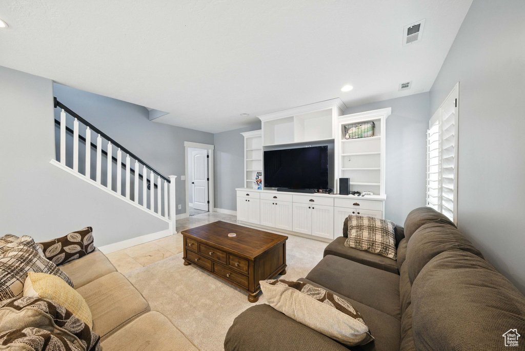 Living room with stairway, recessed lighting, and baseboards