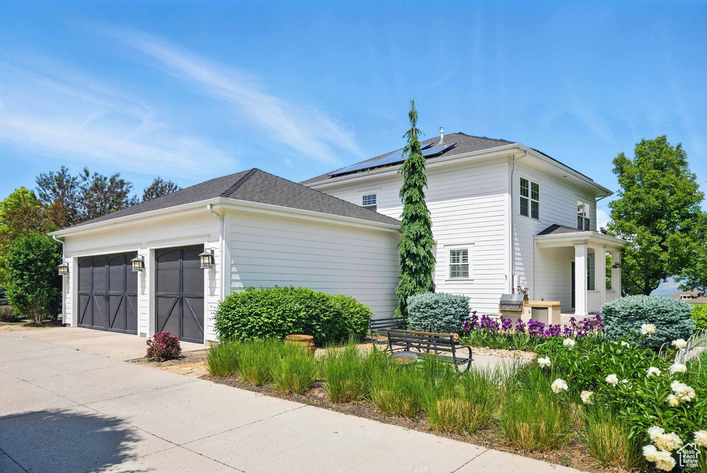 View of side of home featuring concrete driveway and a garage