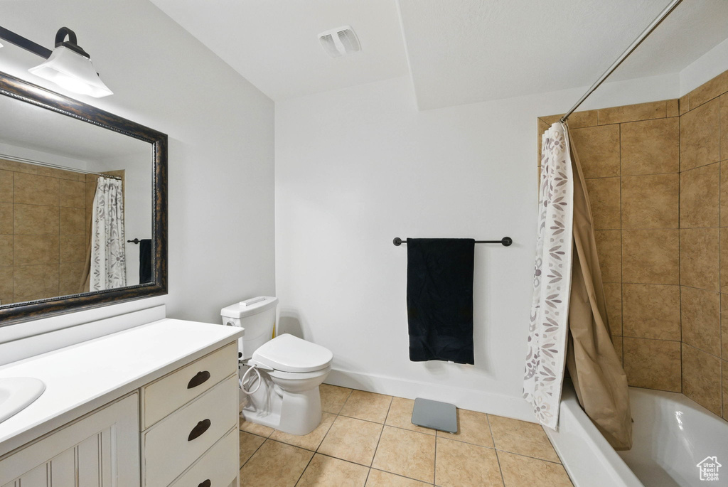 Full bath featuring vanity, toilet, tile patterned floors, and shower / bath combo