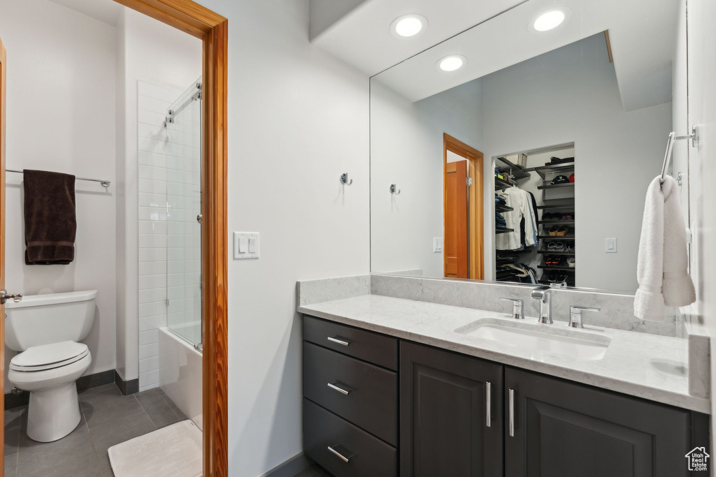 Full bath with vanity, tile patterned flooring, toilet, shower / bath combination, and a spacious closet