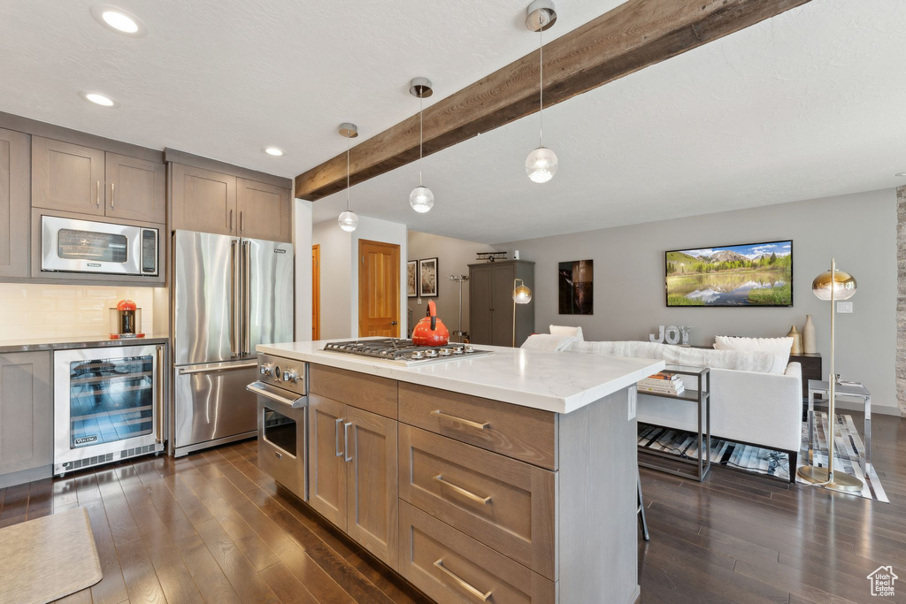 Kitchen with beverage cooler, stainless steel appliances, beam ceiling, dark wood-style flooring, and light countertops