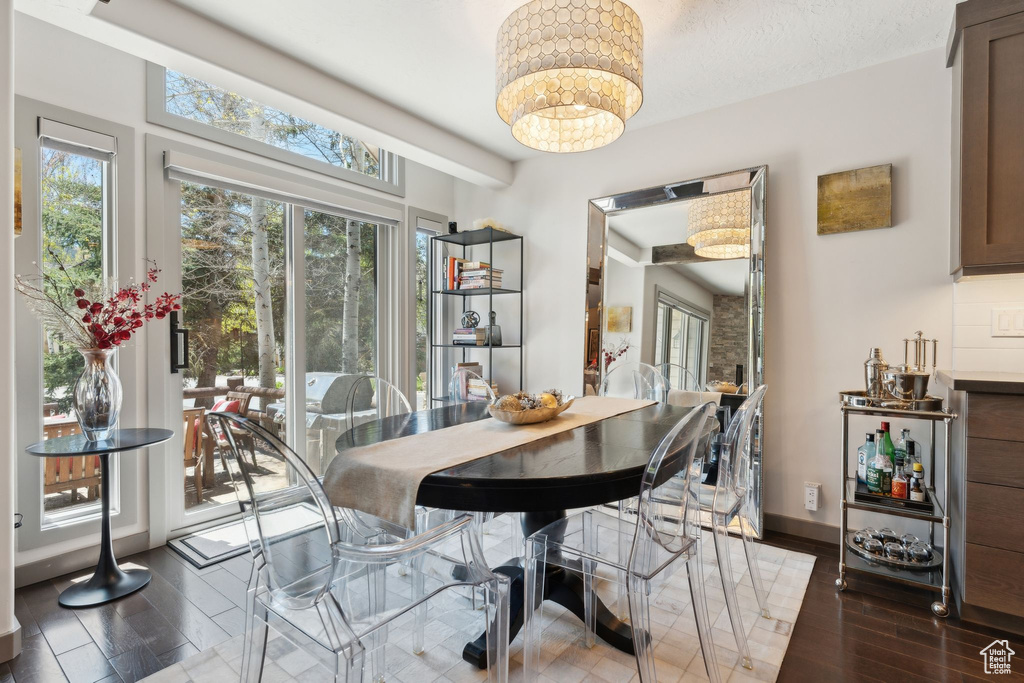 Dining area with wood finished floors, a chandelier, and baseboards
