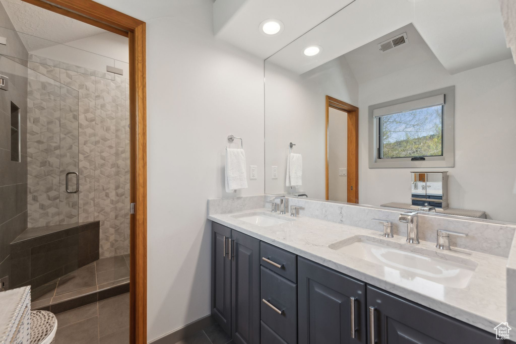 Bathroom featuring double vanity, a shower stall, tile patterned flooring, recessed lighting, and baseboards