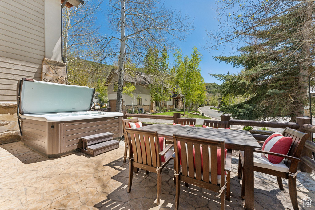 View of patio / terrace featuring a hot tub and outdoor dining space