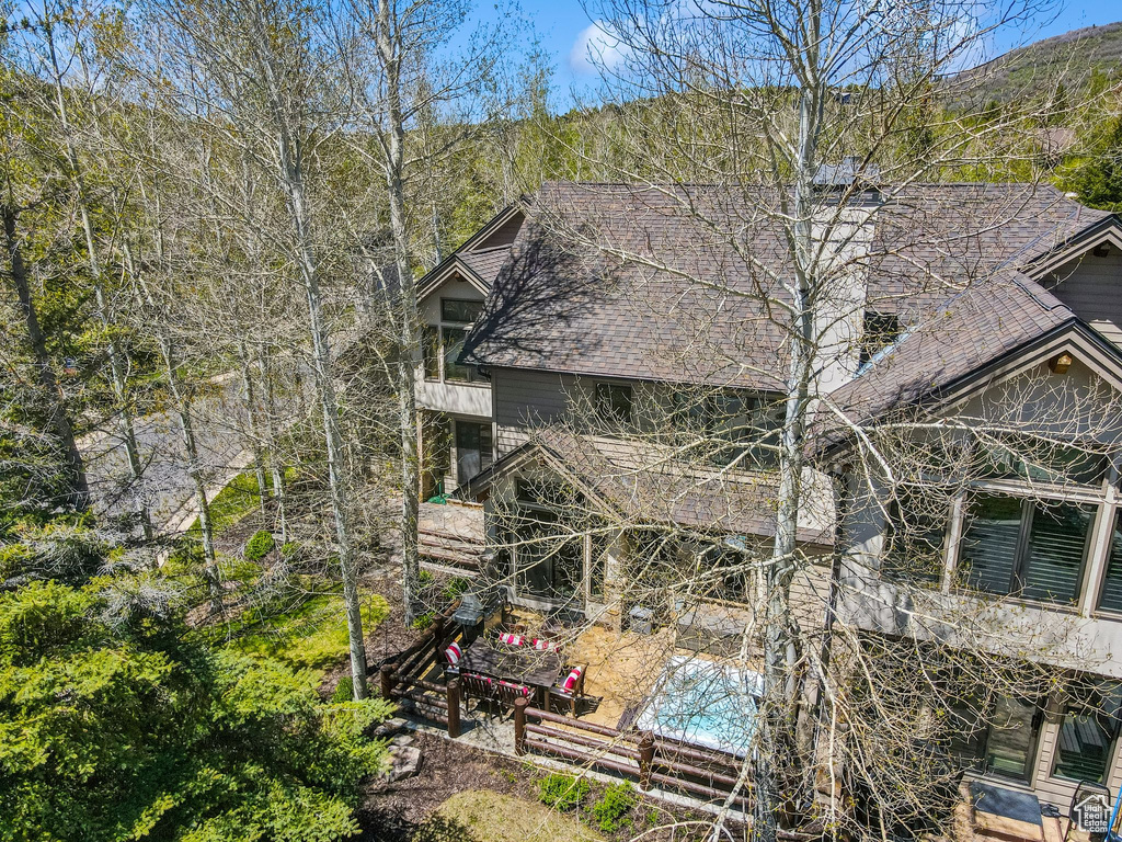 View of property exterior with a chimney, a shingled roof, and a patio area