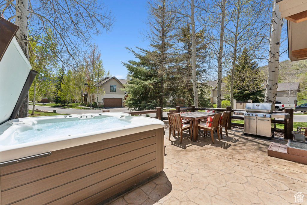 View of patio / terrace with a hot tub and outdoor dining area