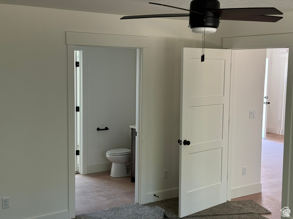 Bathroom with a ceiling fan, wood finished floors, and baseboards