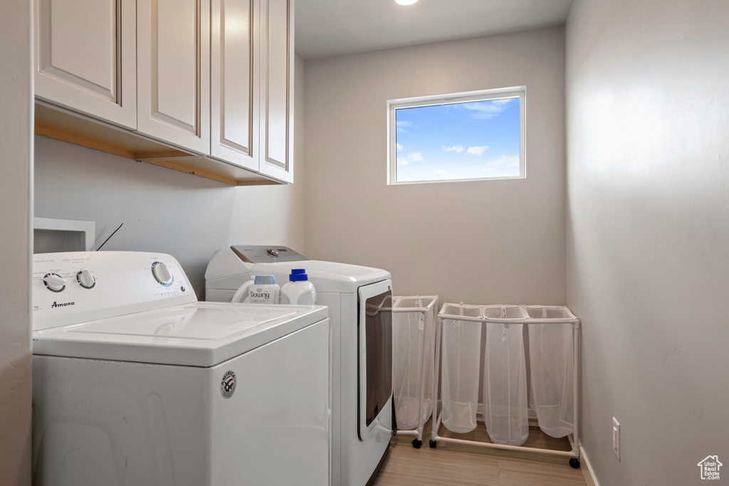 Laundry area featuring cabinet space, washer and dryer, and baseboards