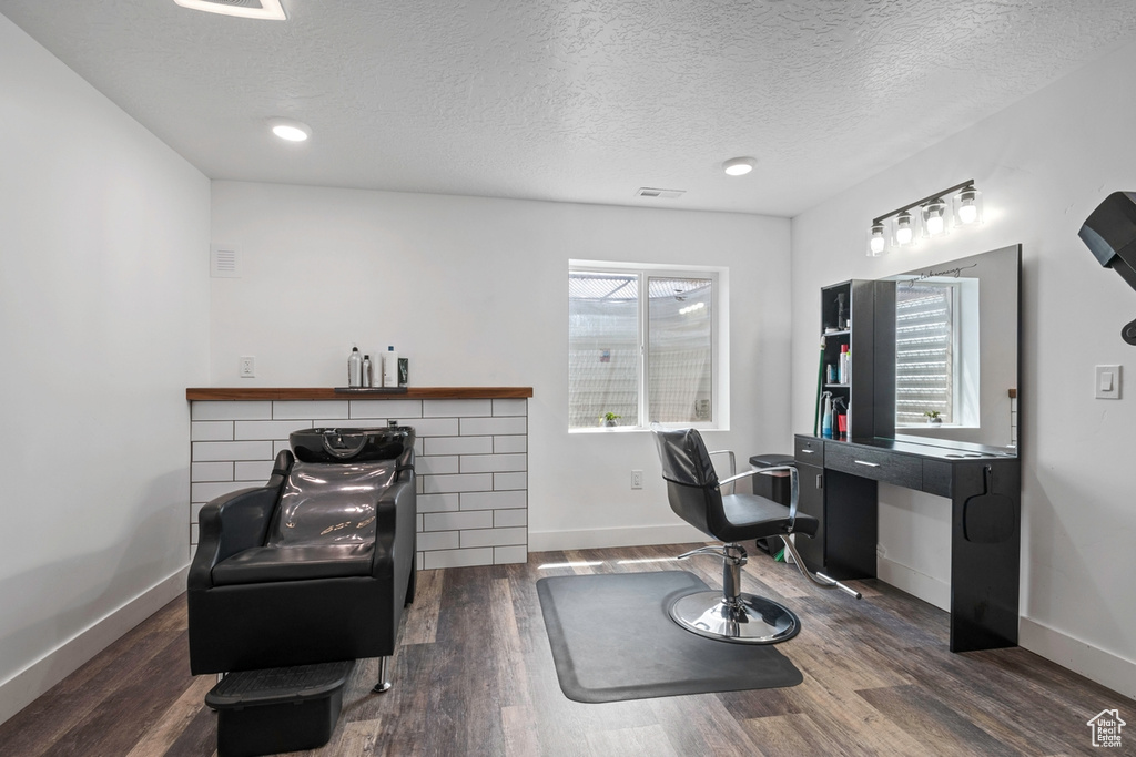 Office with wood finished floors, a textured ceiling, and baseboards