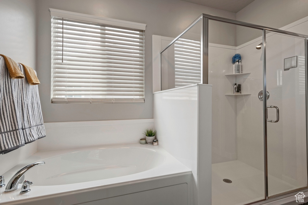 Full bathroom featuring a garden tub and a shower stall