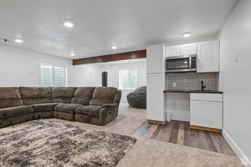 Living area with carpet flooring, recessed lighting, baseboards, and wood finished floors