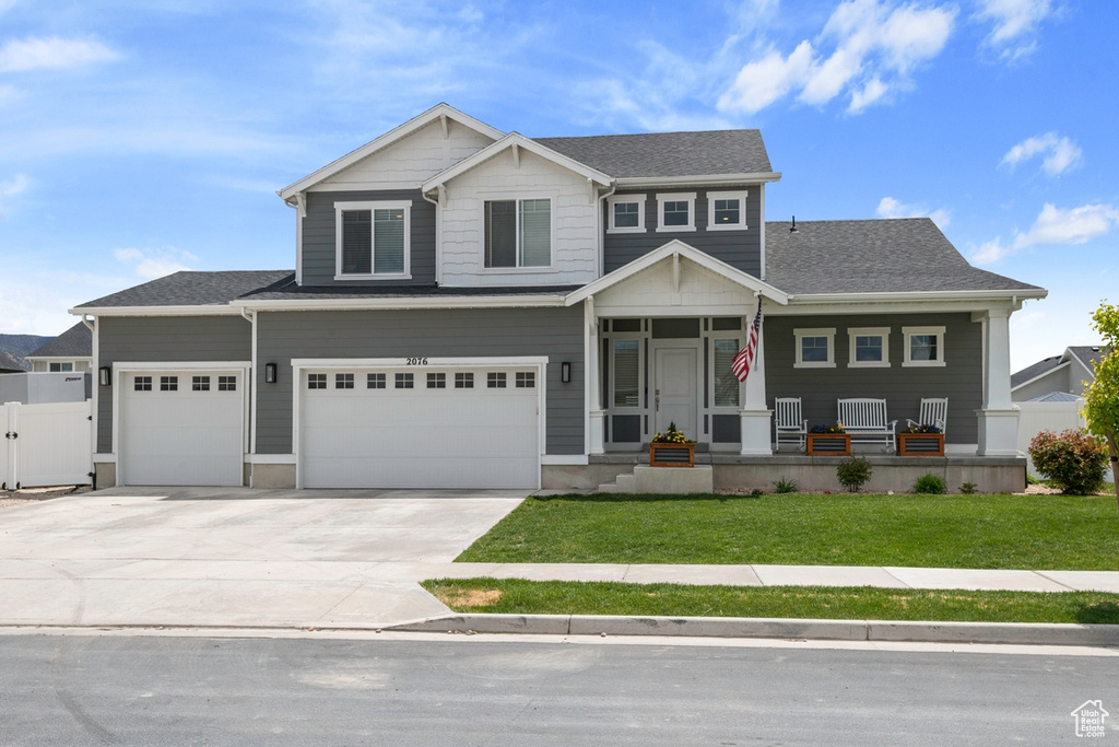 View of front of house featuring a porch, driveway, a garage, and a shingled roof