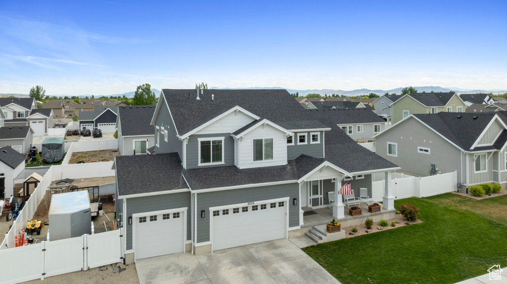View of front of home with a residential view, a shingled roof, a gate, and concrete driveway