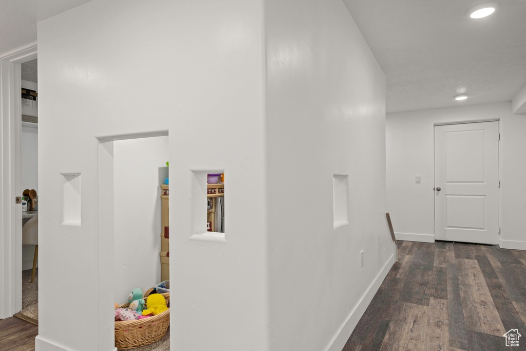 Hallway featuring dark wood finished floors, recessed lighting, and baseboards