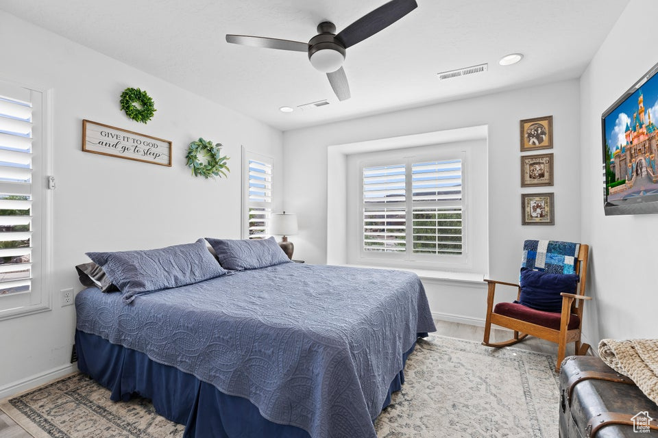 Bedroom featuring wood finished floors, baseboards, and ceiling fan