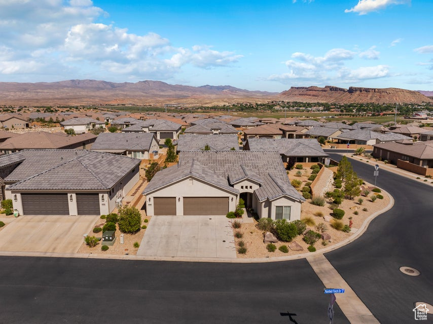 View of front of property featuring a residential view, a garage, concrete driveway, and a mountain view