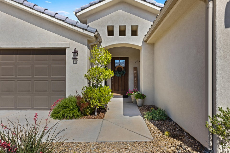 Property entrance with a garage and stucco siding