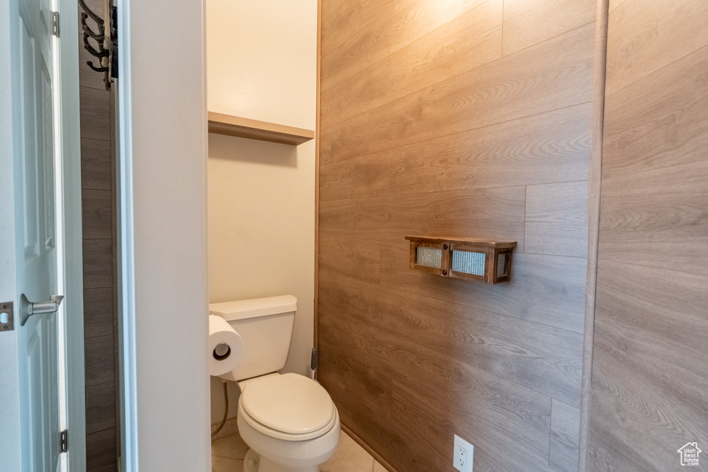 Bathroom with toilet and wood walls