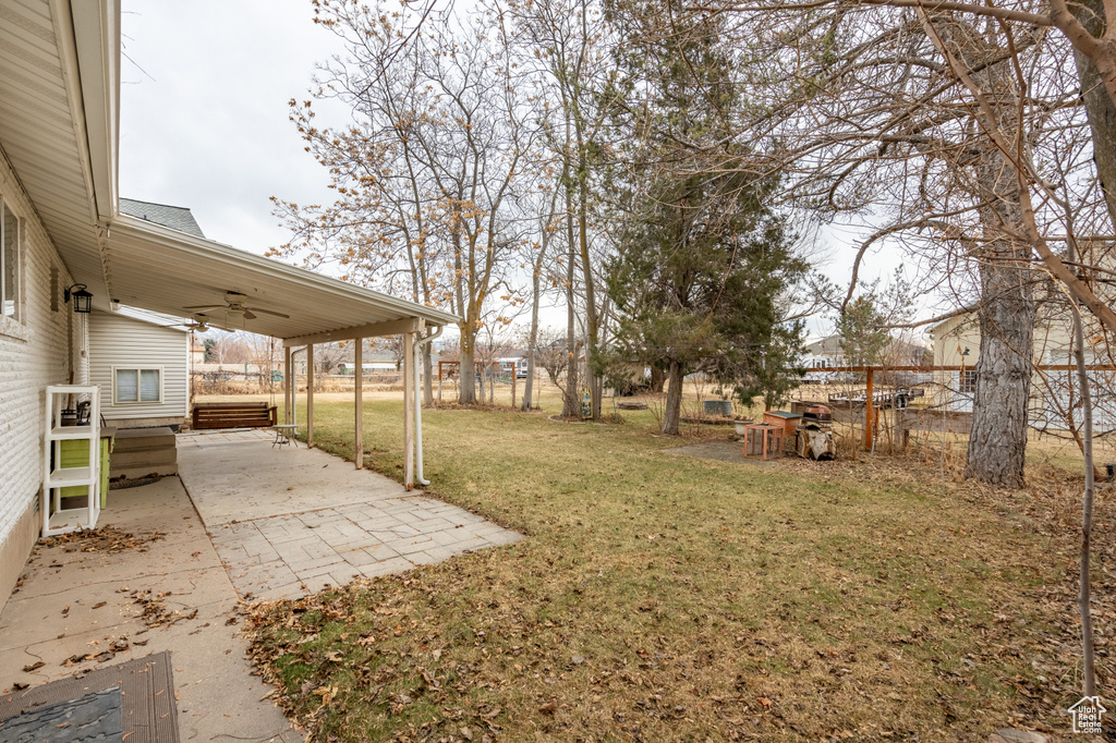 View of yard featuring ceiling fan and a patio area