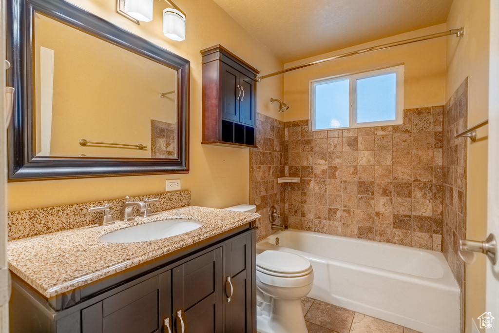 Full bath with toilet, vanity, bathtub / shower combination, and tile patterned flooring