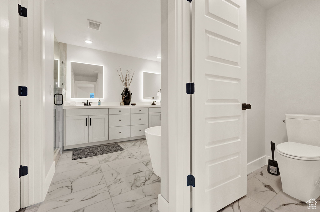 Full bath with marble finish floors, baseboards, double vanity, toilet, and recessed lighting