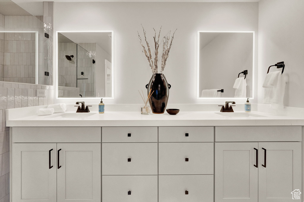 Bathroom featuring double vanity and a shower stall