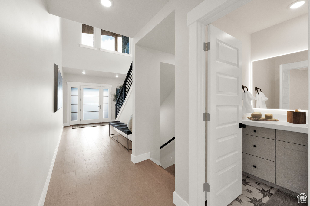Hall featuring baseboards, recessed lighting, and stairs