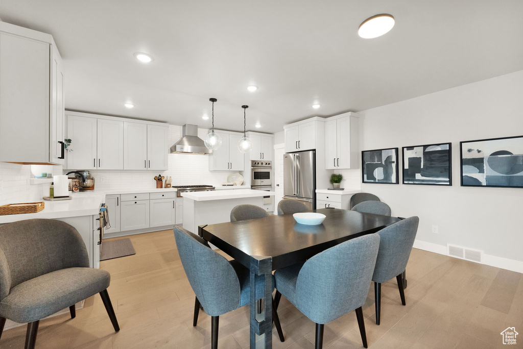 Dining area with recessed lighting, light wood-style floors, and baseboards
