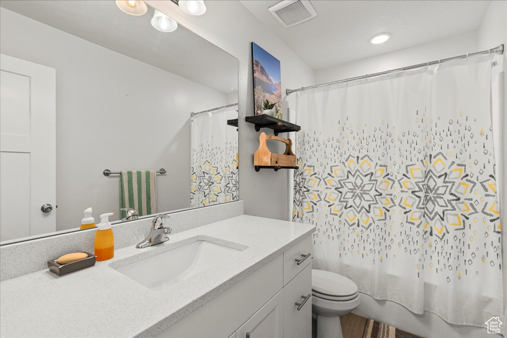 Bathroom with vanity, toilet, a shower with shower curtain, and recessed lighting