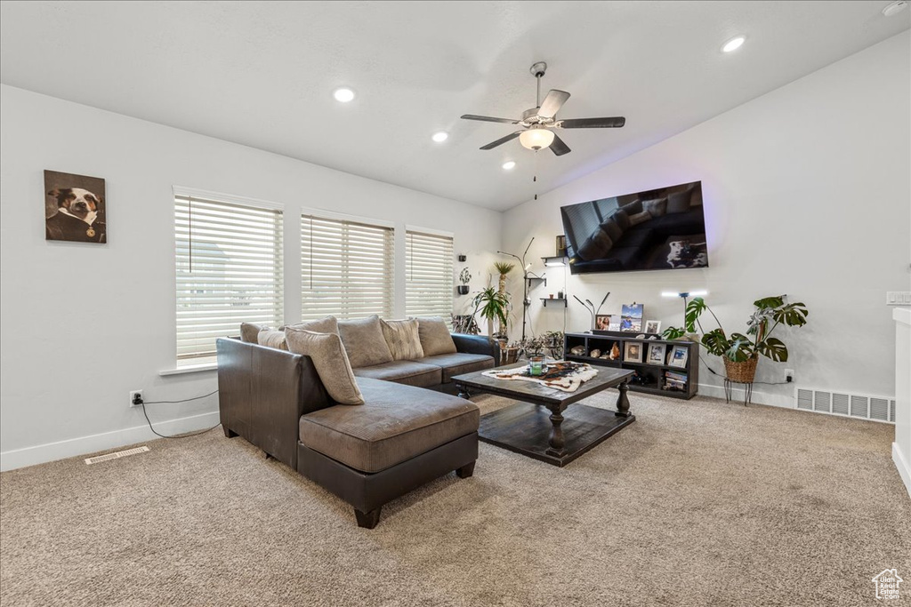 Carpeted living room featuring lofted ceiling, ceiling fan, recessed lighting, and baseboards