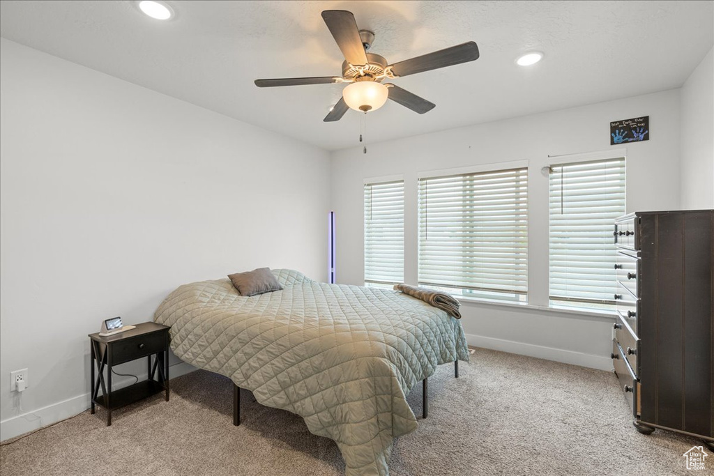 Bedroom featuring light carpet, baseboards, recessed lighting, and a ceiling fan